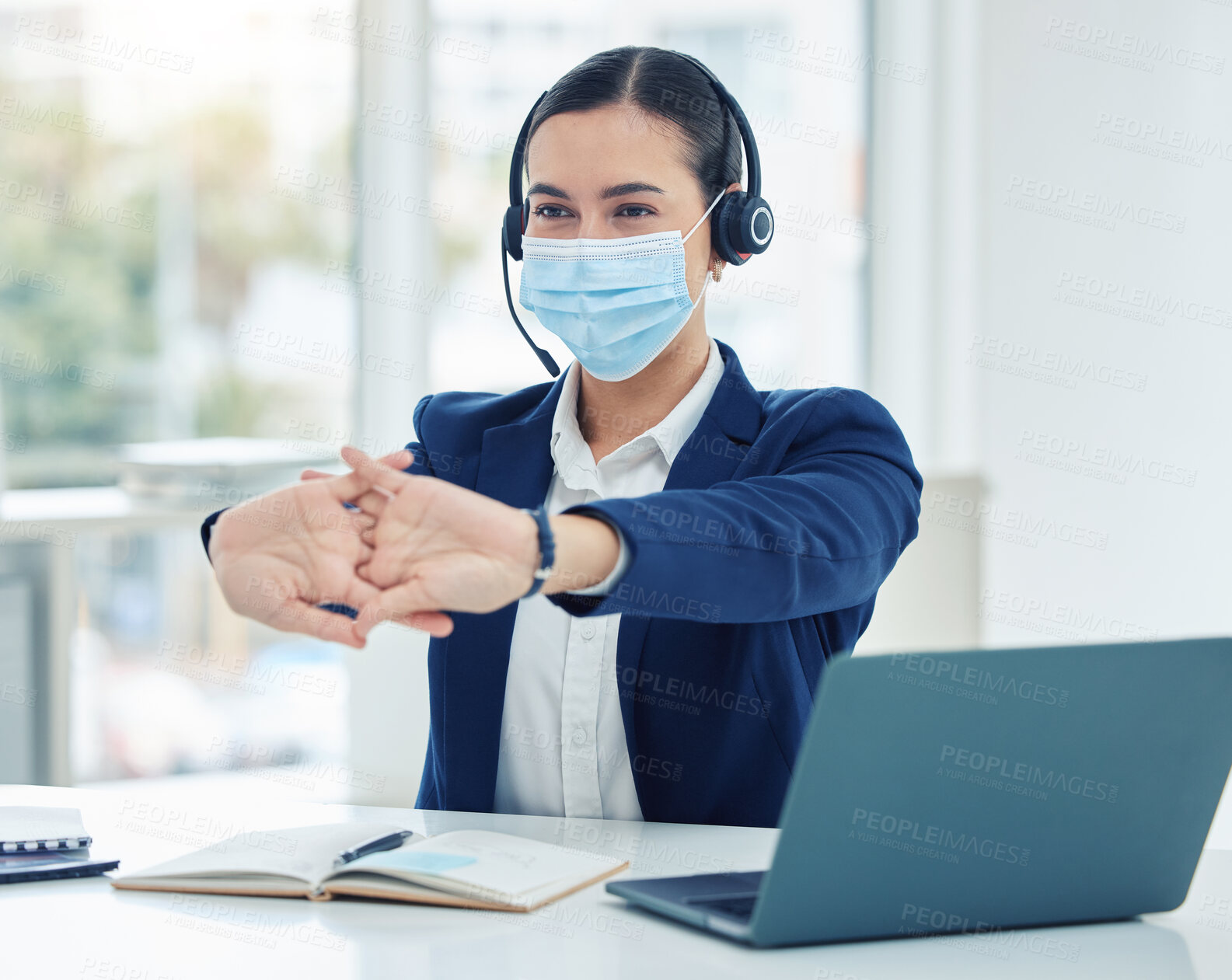 Buy stock photo Call center worker with covid stretching with mask at work and woman resting while consulting with people online on a laptop. Tired customer service worker, consultant and employee working in sales