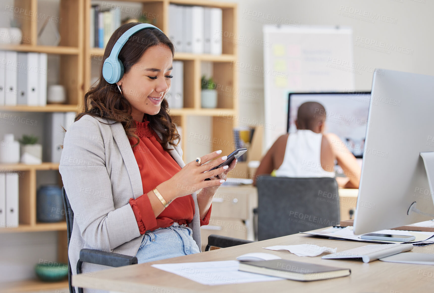 Buy stock photo Phone, music headphones and office computer for woman in creative startup company with team worker. Smile, happy and cool brand designer listening to radio while planning social media design schedule