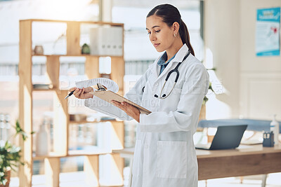 Buy stock photo Insurance, healthcare and medicine with a doctor reading paperwork in a clipboard in her office in the hospital. Medical, review and wellness with a female professional in the health industry