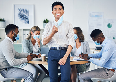 Buy stock photo Meeting, partnership or collaboration by business people during covid in an office planning. Portrait of an Asian male corporate employee happy to remove a coronavirus face mask at end of a pandemic