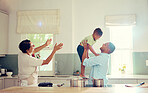 Family, father and son in the kitchen with happy, playful and joy time at home smiling in happiness. Parents in care, love and fun with child together in a house playing with smile and funny moments.