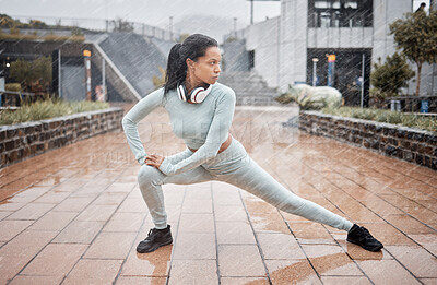 Buy stock photo Rain, outdoor fitness and runner stretching for winter exercise, health training or start workout. Warm up, water drop and black woman focus with headphones for listening to music, podcast or radio