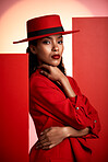 Fashion, studio and stylish woman in a suit with a seductive, sensual and elegant outfit. Edgy, fashionable and portrait of female African model with trendy style posing by orange and red background.