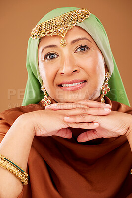 Buy stock photo Portrait, Islamic woman and fashion with culture jewelry, head scarf and mature beauty on brown studio background. Senior female, Muslim lady and traditional outfit, Arabic aesthetic and cosmetics.