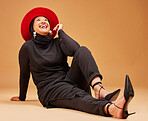 Muslim, happy woman and laughing on studio background with fashion, trendy hat and luxury style. Smile, happiness and mature islamic model with beauty, confidence and hijab culture on orange backdrop