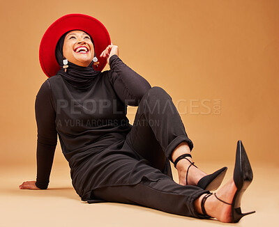 Buy stock photo Muslim, happy woman and laughing on studio background with fashion, trendy hat and luxury style. Smile, happiness and mature islamic model with beauty, confidence and hijab culture on orange backdrop