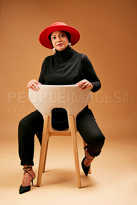 Buy stock photo Muslim woman, chair and fashion, beauty and hat with trendy outfit, focus attitude and studio background. Mature Indonesia model, portrait and islamic culture, hijab lifestyle and luxury clothes 