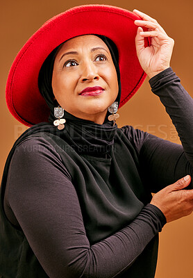 Buy stock photo Fashion, beauty and model with a senior muslim woman in studio in a brown background for clothes style. Trendy, hat and idea with a stylish mature islamic female posing in contemporary clothing