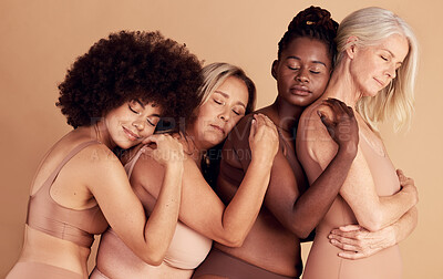 Buy stock photo Beauty, diversity and group in lingerie hug for skin color underwear campaign with comfortable body pose. Young, senior and interracial body positive model women on beige studio background.

