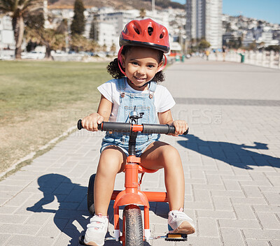 Buy stock photo Portrait, girl child and cycling on sidewalk, learning to ride bike or healthy childhood development. Happy kid riding tricycle with helmet, safety and outdoor fun in summer, sunshine and Atlanta USA