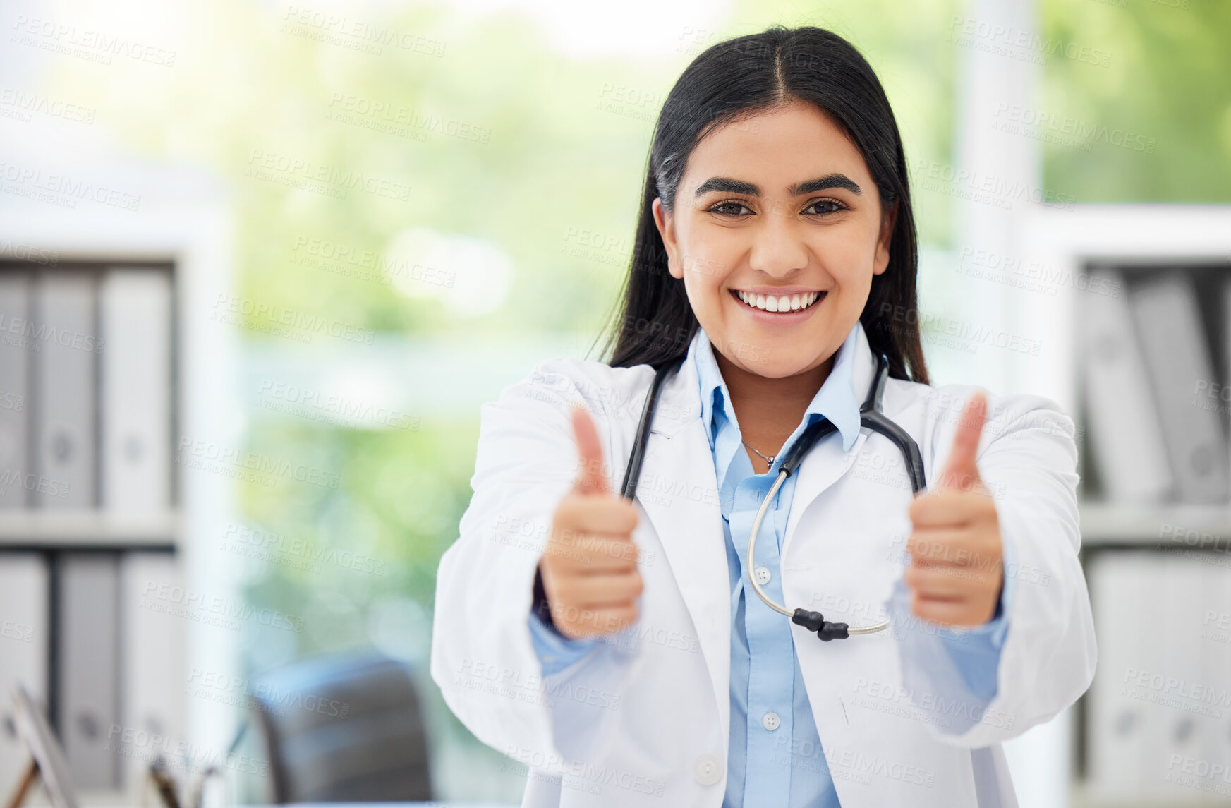 Buy stock photo Excited medical doctor showing thumbs up for success working at hospital, giving support after and happy with service in an office at clinic. Portrait of healthcare worker showing winning hand sign