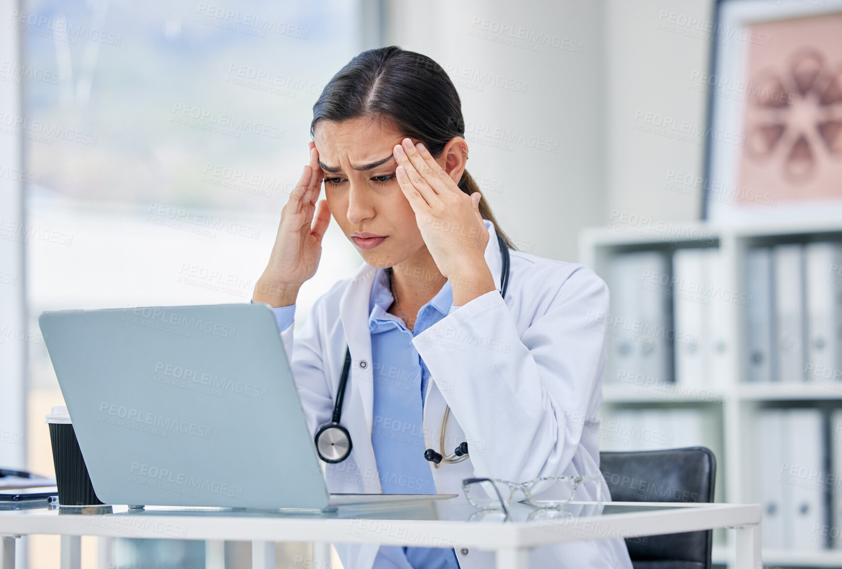 Buy stock photo Stress or burnout with doctor thinking and working on laptop in hospital consulting room or office. Medical healthcare worker or specialist surgeon with anxiety headache from mental health issues