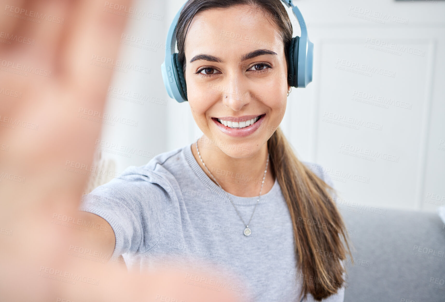 Buy stock photo Portrait of happy woman take selfie and smile with headphones while listening to music in the living room. Young beautiful lady streaming a podcast at home and relax in lounge and express happiness