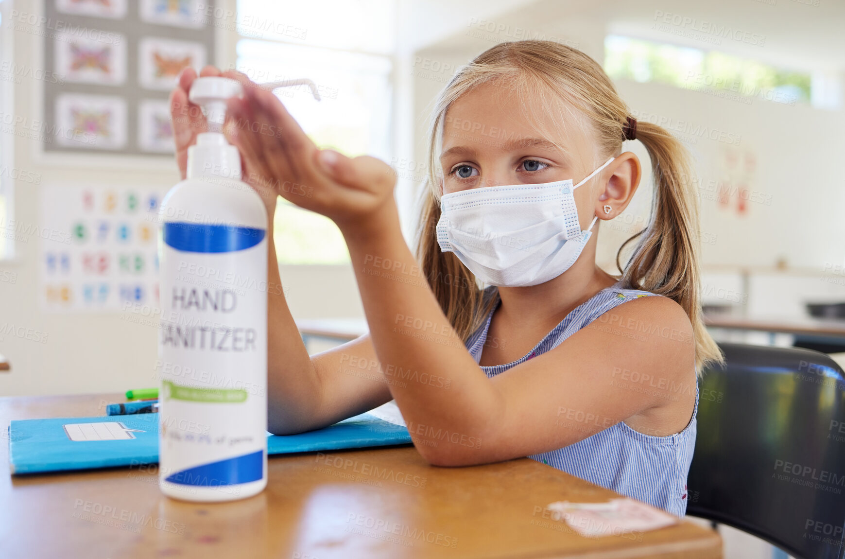 Buy stock photo Little student sanitizing hand to protect from covid, wearing a mask and following new hygiene safety routine. Kindergarten or preschool female learner protecting herself from corona virus flu