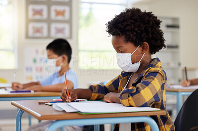 Buy stock photo School student in class during covid pandemic for learning, education and study with mask for safety, protection and protocol. Little kindergarten, preschool or elementary kid writing in book at desk