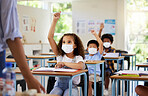 Covid, education and learning of eager, smart and clever children raising hands and wearing masks in a classroom. Teacher or educator asking questions for knowledge test at kids school in a pandemic.