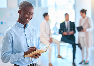 Buy stock photo Assistant writing notes in a notebook for a team of executive people and is happy with a positive mindset, vision and mission. African American business man using a journal or diary for his schedule