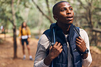 Hiking young black man in forest nature with wow face traveling with backpack in woods. Surprise, happy and active African person or backpacker in trees trekking on jungle freedom adventure in summer