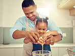 Happy black father and daughter baking in a kitchen, having fun being playful and bonding. Caring parent teaching child cooking and domestic skills, prepare a healthy, tasty snack or meal together