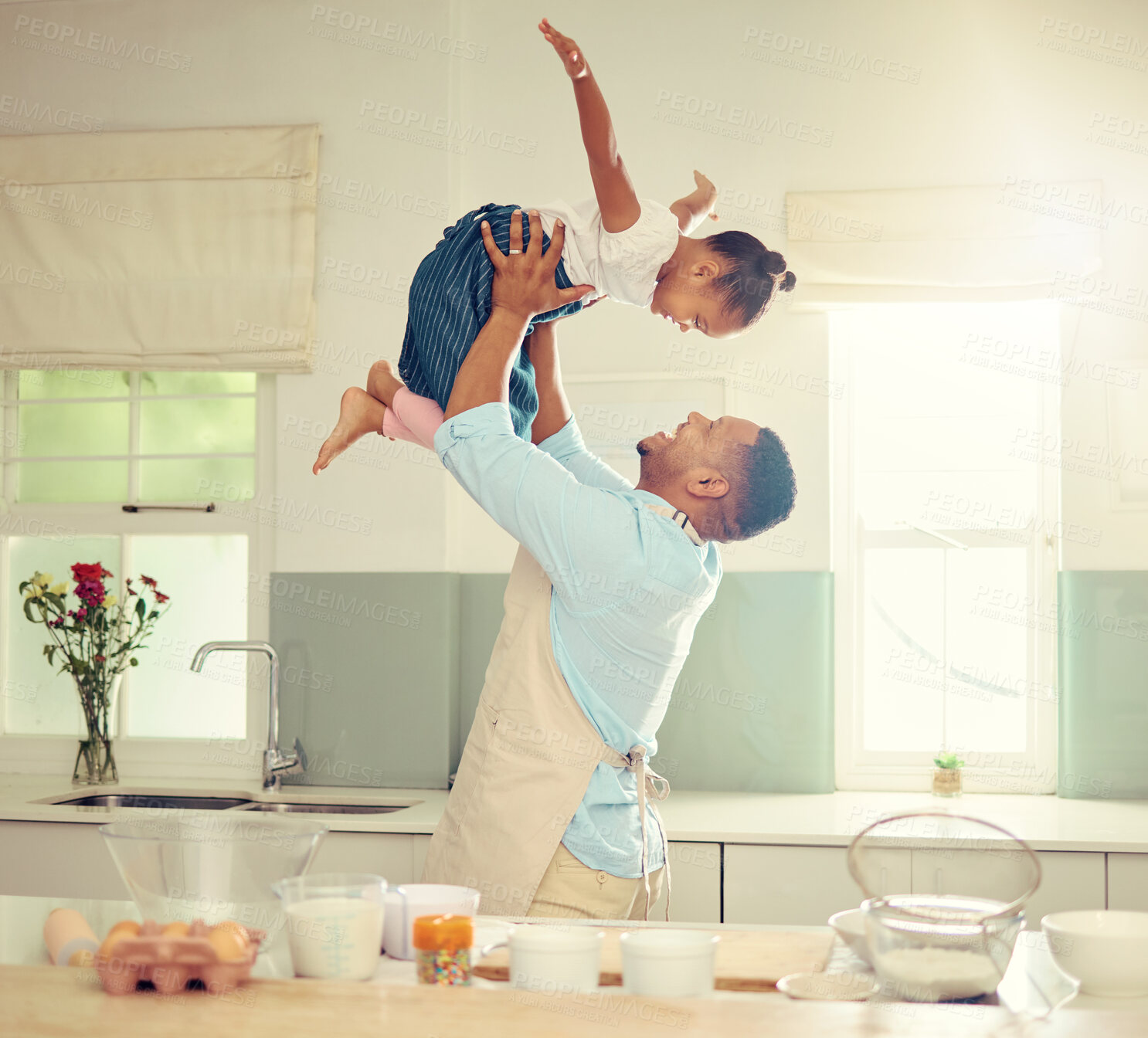 Buy stock photo Happy black father and daughter playing in a kitchen while cooking together, bonding and laughing. African American parent enjoying family time with his child, playful and having fun while baking