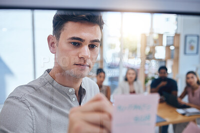 Buy stock photo Business man writing on sticky note in meeting, doing creative advertising presentation on glass board in workshop and training employees in work office. Corporate worker planning on post it paper