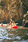 Travel, kayak and female friends on an adventure while on a lake or sea with a mountain view in nature. Women having fun while traveling and enjoying water activity while on a vacation holiday trip