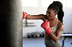 Boxer, workout and training girl with punching bag working on sports fitness, exercise and strength. Athlete, fighter or black woman in a boxing, health and wellness gym or martial arts fight club