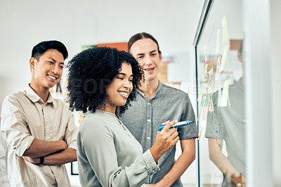 Buy stock photo Diversity, teamwork and brainstorming, a team of startup employees with sticky notes in an office. Happy young black woman writing on a white board with idea from businessmen at workshop or meeting 