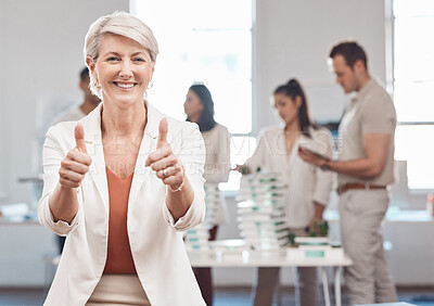Buy stock photo Thumbs up, motivation and yes with a woman leader, manager or CEO working in an office with her team in the background. Thank you, winner and success with a mature female business woman at work