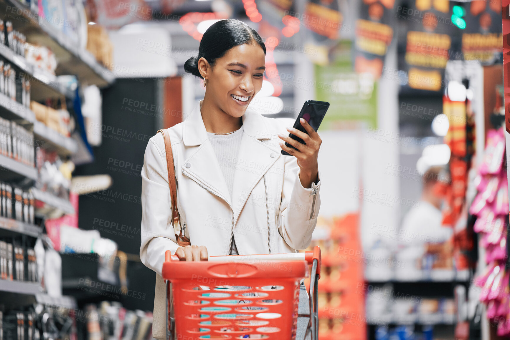 Buy stock photo Phone, 5g internet and grocery shopping Indian woman reading a funny text or social media content. Comic web, mobile and online scroll at a retail food store with a happy customer smile from India 