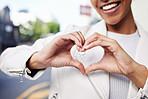 Hands, heart and sign of a black woman with smile in care, support and joy against city background. Happy African American female happy and smiling with love gesture or hand sign at a urban town