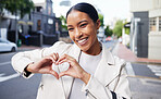 Portrait of a happy woman doing a heart shape with her hands while on health walk in the city street. Beautiful girl with a smile showing the love sign while standing outdoor in the town road.
