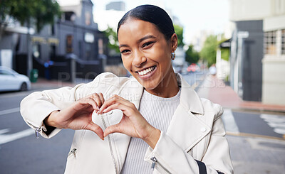 Buy stock photo Portrait of a happy woman doing a heart sign with her hands while on health walk in the city street. Beautiful girl with a smile showing the love shape while standing outdoor in the town road.