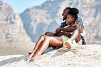 Beach, black couple and happy woman and man on rock with South Africa mountain background on summer holiday travel. Smile, relax people and enjoy view on nature in security, trust or safety love bond