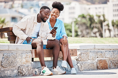 Buy stock photo Black couple, love and phone while browsing social media, internet or watching a video while sitting on a park bench. Happy man and woman on a romantic date, trip or summer holiday to relax together