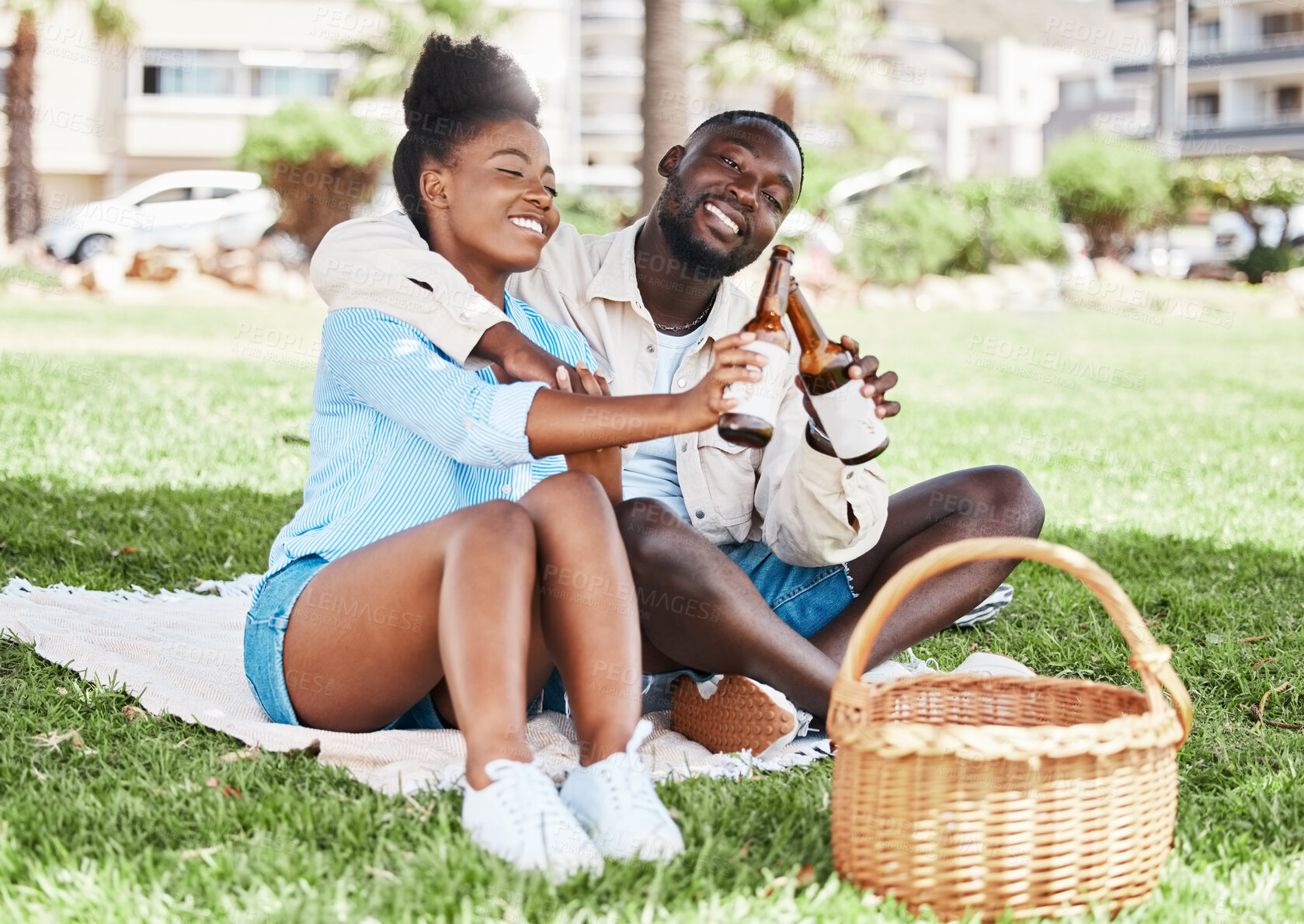 Buy stock photo Couple on garden picnic date, black woman and drink bottle of beer together. Young african man, drinking alcohol and happy girl. Outdoor nature, park in city and love relationship time together