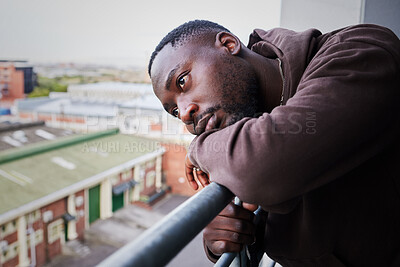 Buy stock photo Sad, tired and depressed man on balcony of apartment, thinking of mental health in house and anxiety from problem at home. Face of African person with depression and burnout thinking of idea