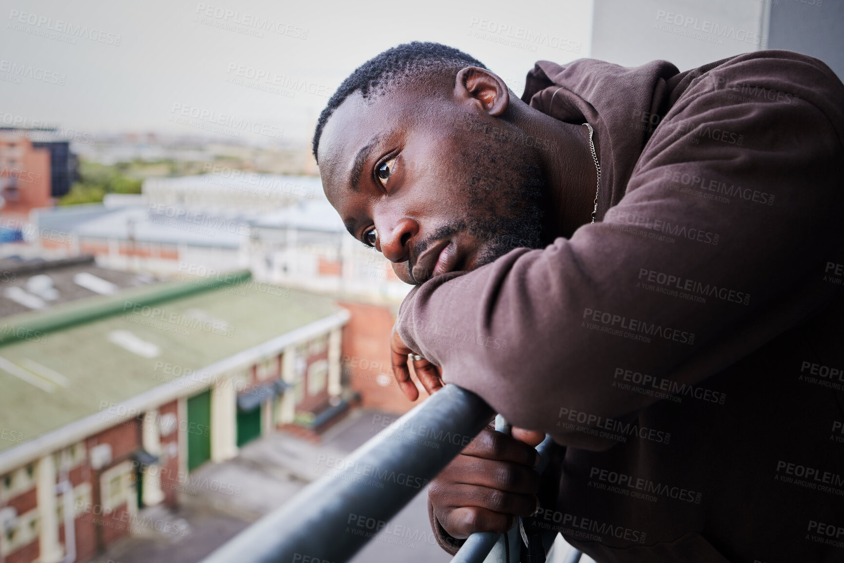 Buy stock photo Sad, tired and depressed man on balcony of apartment, thinking of mental health in house and anxiety from problem at home. Face of African person with depression and burnout thinking of idea