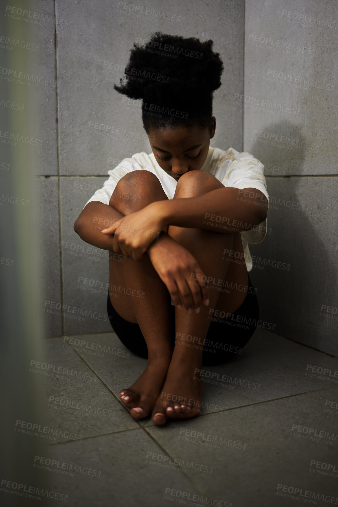 Buy stock photo Sad, unhappy and depressed student sitting alone on the floor of a bathroom in school. Lonely, upset and depressed teen girl struggling with bullying and mental health in the corridor