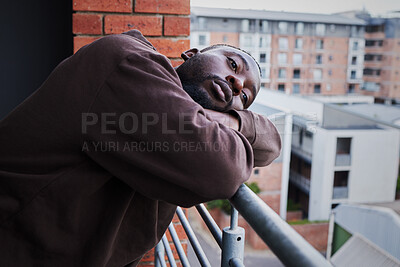 Buy stock photo Depression in covid pandemic with a sad man suffering from mental illness, lonely while outside on a balcony. Unhappy male feeling hopeless and annoyed, frustrated with compliance and corona rules 