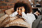 Depressed, sad and frustrated African woman thinking of idea with anxiety, problem with mental health and depression on the sofa in home. Frustrated, fear and tired girl with stress  on house couch