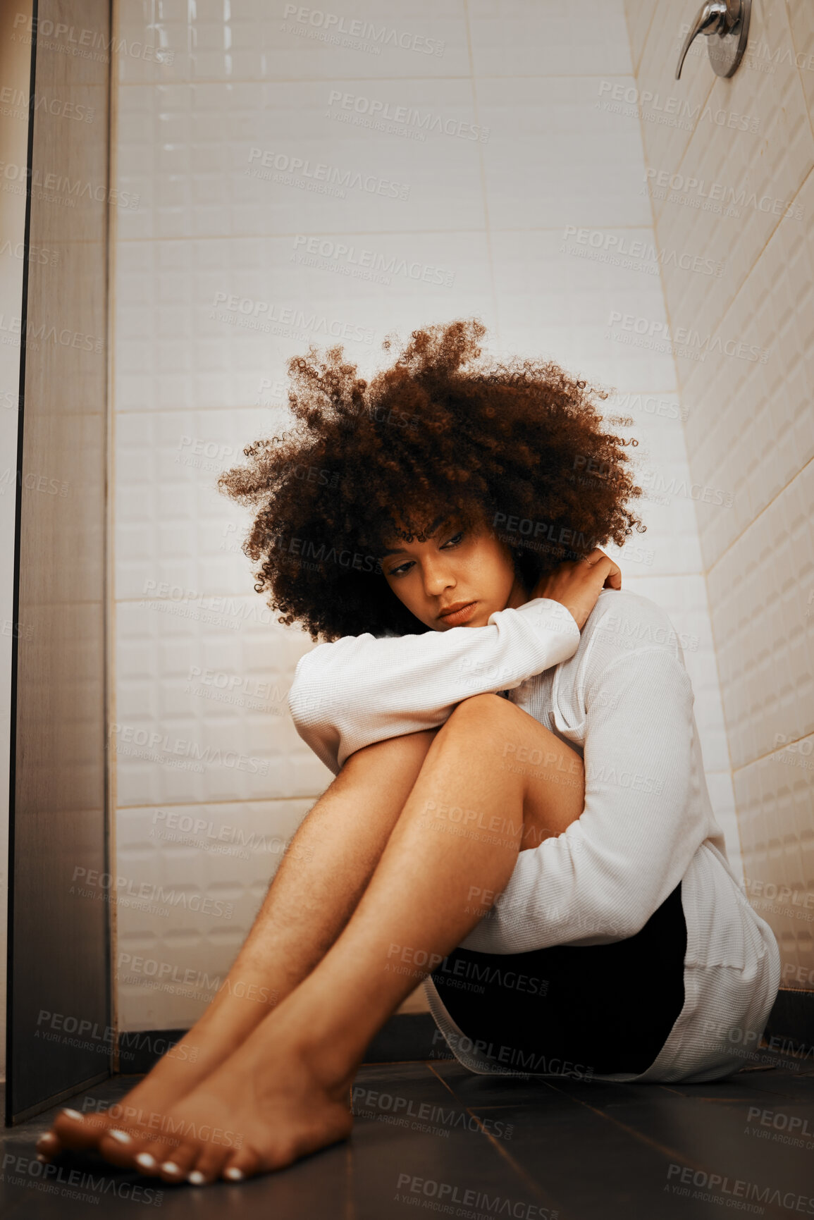 Buy stock photo Depression, anxiety and a sad black woman on the floor sitting in a shower or bathroom. Mental health, crying and the stress of life in youth, scary thoughts for depressed young lady alone with fear