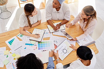 Buy stock photo Creative team planning a project with digital tablet and paperwork in corporate office. Top view of professional employees writing notes and analyzing documents with graphs, charts and color wheels.