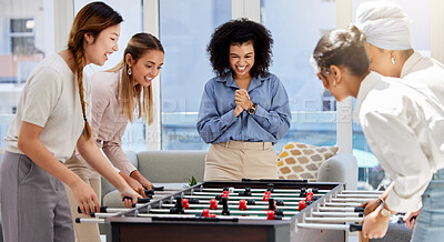 Buy stock photo Team building, break and business women playing game in office lounge room having fun and bonding together. Trendy, cool and diversity of creative staff with fun mini table football match activity