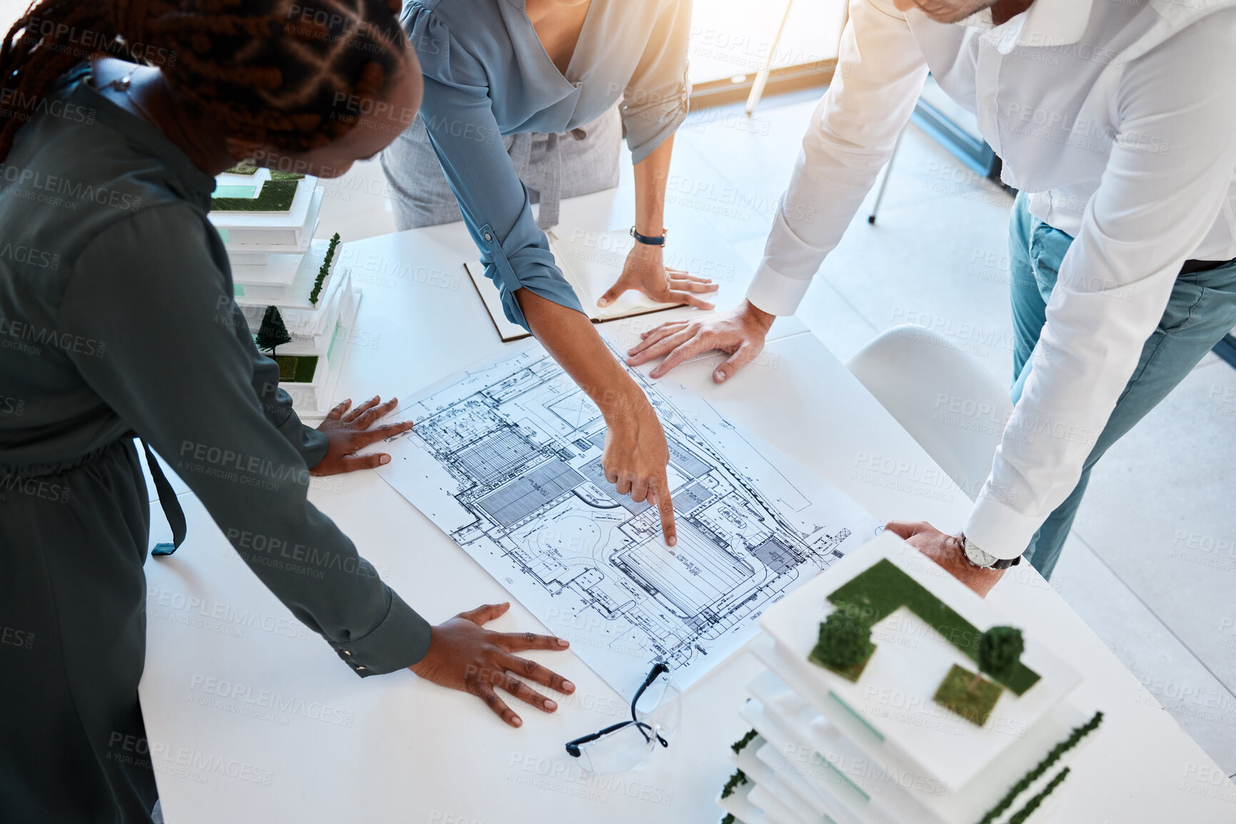 Buy stock photo Architect, team and planning building blueprint in office for coworkers to look at before construction. Workers looking at designs and scale model for future architecture in corporate work setting.
