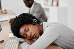 Call center, burnout and sleep of a woman employee resting on a desk at the office. Exhausted black female telemarketing agent or consultant in customer support or service sleeping on the job at work
