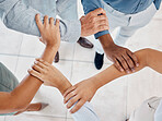 Hands, teamwork and collaboration with a team of business people holding arms in a huddle or pentagon from above. Trust, support or motivation of group at work or office in solidarity, unity or union