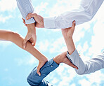 Teamwork, hands and collaboration with a team of business people holding arms in a circle or huddle on a blue sky from below. Motivation, trust and support with a group in unity or solidarity outside