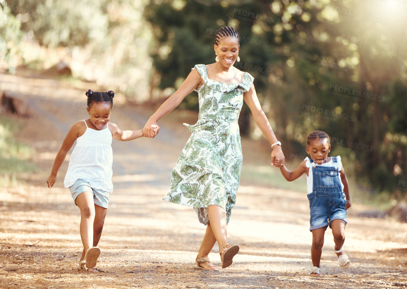 Buy stock photo Happy, mother and kids walking in a forest holding hands in nature in joyful happiness and smiling. Black family of a mom and her little girls bonding on a fun walk in the natural outdoor environment