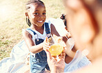 Happy girl, juice and smile in family picnic fun and joy in happiness on a warm summer day in nature. Black child smiling for fresh cold healthy beverage in the hot outdoors with parent and sibling